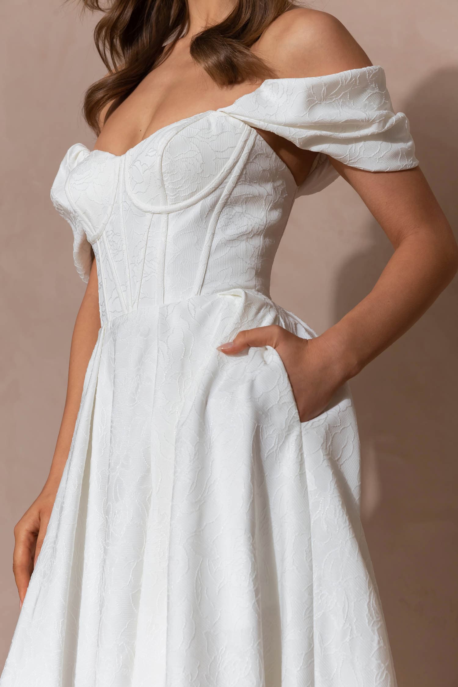 Frau in hochgeschlossenem Brautkleid aus fließendem Crepe Stoff mit Taillenband mit Schleife