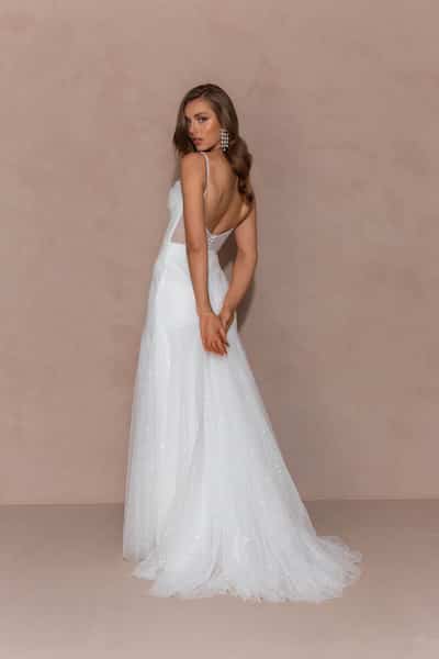 Cleanes Brautkleid aus Satin mit V-Ausschnitt und fließendem Rock an Frau mit Schleier und Brautstrauß