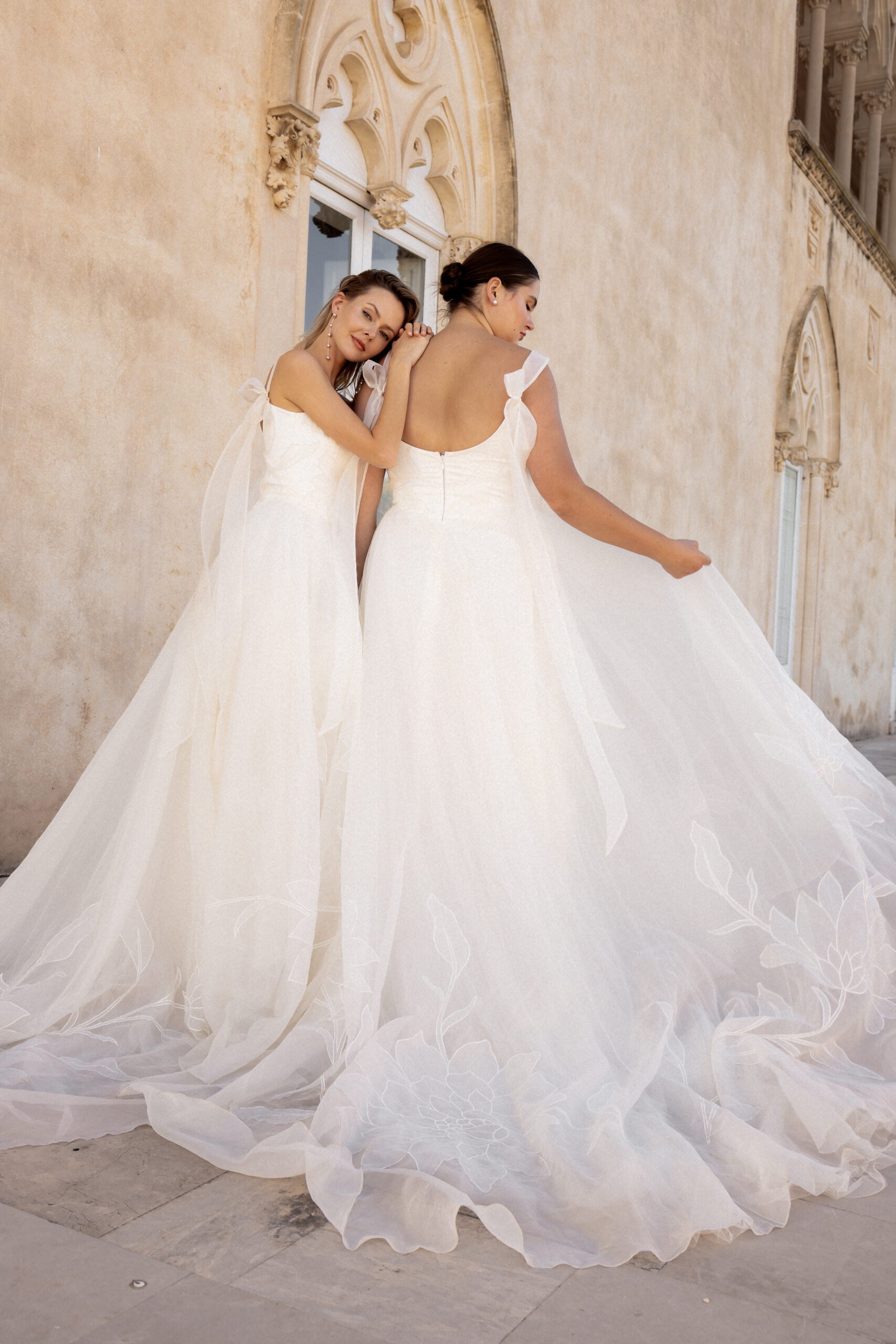 A-Linien Brautkleid mit Organza Trägern, einer langen Schleppe und Baskentaille. Verziert mit großer Blumenstickerei auf dem Top und im Rock.